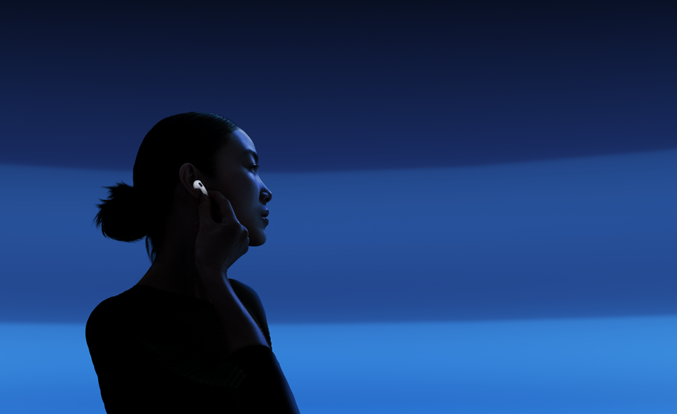 Iemand die met duim en wijsvinger de steel van AirPods 5 vasthoudt om de luistermodus te wijzigen