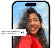 iPhone 15 waarop de VoiceOver-feature informatie geeft over een foto van een lachende persoon met golvend zwart haar